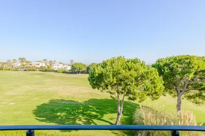 a view from a balcony of a golf course with trees at Casa Lomy - Boavista Resort and Spa in Quatro Estradas
