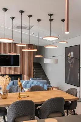 a dining room with a table and chairs and pendant lights at The Cliffhouse by LovelyStay in Fajã da Ovelha