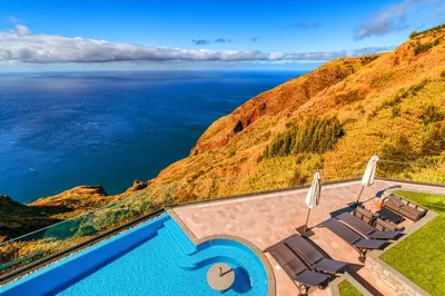 a swimming pool with a view of the ocean at The Cliffhouse by LovelyStay in Fajã da Ovelha