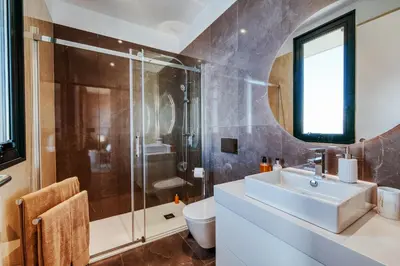 a bathroom with a sink and a shower and a toilet at The Cliffhouse by LovelyStay in Fajã da Ovelha