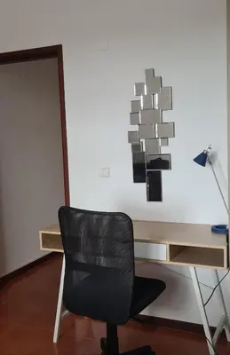 a black chair sitting in front of a wooden desk at Scenic Comfort D in Ponta Delgada