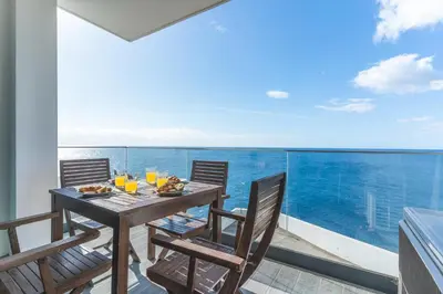 a table and chairs on a balcony with a view of the ocean at Belle Vue Résidence by Atlantic Holiday in Santa Cruz