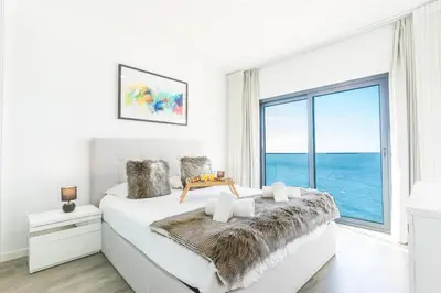 a bedroom with a large bed with a large window at Belle Vue Résidence by Atlantic Holiday in Santa Cruz
