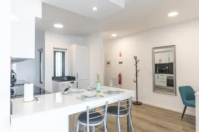 a kitchen with a white counter and chairs in a room at Belle Vue Résidence by Atlantic Holiday in Santa Cruz