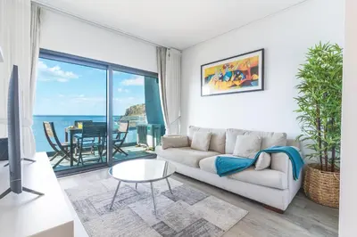 a living room with a couch and a view of the ocean at Belle Vue Résidence by Atlantic Holiday in Santa Cruz