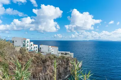 a building on a cliff next to the ocean at Belle Vue Résidence by Atlantic Holiday in Santa Cruz