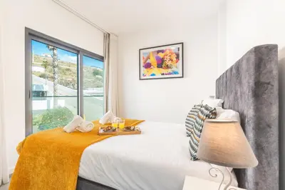a white bedroom with a bed and a window at Belle Vue Résidence by Atlantic Holiday in Santa Cruz