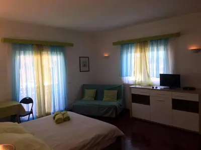 a bedroom with two beds and a desk with a television at Lagos Room Booking in Lagos