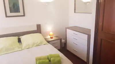 a bedroom with a bed and a dresser with a lamp at Lagos Room Booking in Lagos