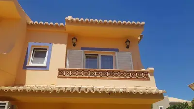 a yellow house with windows and a balcony at Lagos Room Booking in Lagos