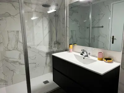 a bathroom with a sink and a glass shower at Maria's Central View in Funchal