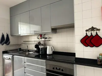 a kitchen with white cabinets and a sink at Maria's Central View in Funchal