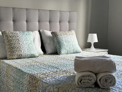 a bedroom with a large bed with pillows and a bedspread at Maria's Central View in Funchal
