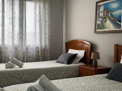 a bedroom with two beds and a picture on the wall at Maria's Central View in Funchal