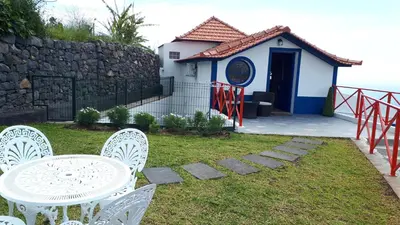 a table and two chairs on a balcony with the ocean at Casa Villa Dinastía Sótão Y Casa Villa Dinastía Miramar in Ribeira Brava