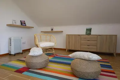 a living room with a chair and two balls on a rug at Casa das Feiteiras by AnaLodges in Ponta Delgada