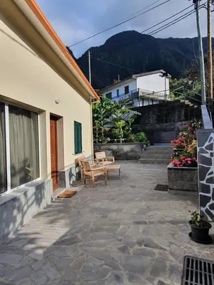 a patio with two chairs and a bench next to a building at Casa das Feiteiras by AnaLodges in Ponta Delgada