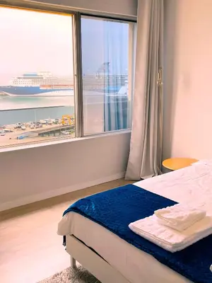 a bedroom with a bed and a window with a cruise ship at top floor arriaga apartment 804 in Funchal