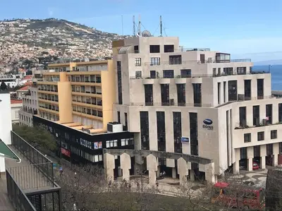 a large white building next to the ocean at top floor arriaga apartment 804 in Funchal