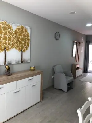 a living room with white cabinets and a chair at Casa das Palmeiras in Calheta