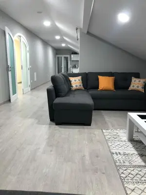 a living room with a black couch and orange pillows at Casa das Palmeiras in Calheta