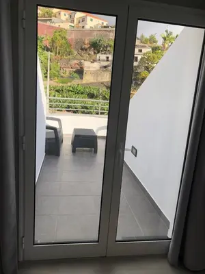 a glass door with a view of a balcony at Casa das Palmeiras in Calheta