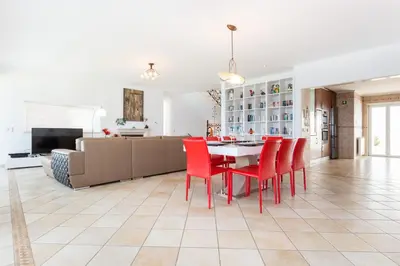 a kitchen and living room with a table and red chairs at CoolHouses Algarve Luz, Ocean front 4 Bed house w/ pool, Casa da Pipa in Luz