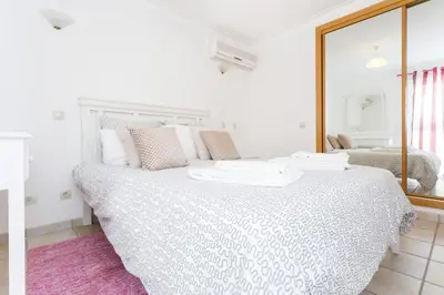 a bedroom with a large white bed with a mirror at CoolHouses Algarve Luz, Ocean front 4 Bed house w/ pool, Casa da Pipa in Luz