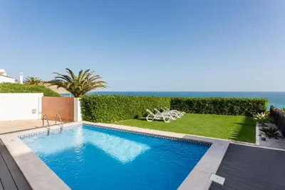 a swimming pool with a view of the ocean at CoolHouses Algarve Luz, Ocean front 4 Bed house w/ pool, Casa da Pipa in Luz
