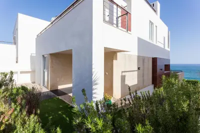 a white house with the ocean in the background at CoolHouses Algarve Luz, Ocean front 4 Bed house w/ pool, Casa da Pipa in Luz