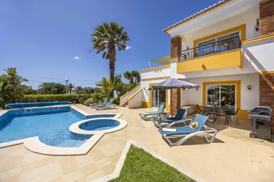 a balcony with a table and chairs and palm trees at CoolHouses Algarve Luz, 2 Bed semi detached villa, Jardim das Palmeiras condominium, Villa A in Montinhos da Luz