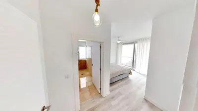 a white room with a bed and a hallway at Villa Cassolino in Ribeira Brava