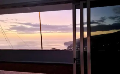 a view of a sunset from a window at Villa Cassolino in Ribeira Brava