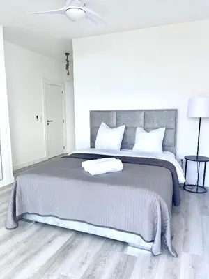 a white bedroom with a large bed with white pillows at Villa Cassolino in Ribeira Brava