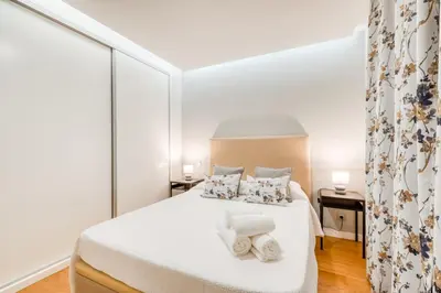 a bedroom with a white bed with towels on it at Casa da Praia by Amazing Madeira in Caniço