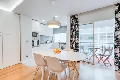 a kitchen and dining room with a white table and chairs at Casa da Praia by Amazing Madeira in Caniço