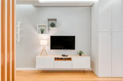 a living room with a tv on a white wall at Casa da Praia by Amazing Madeira in Caniço