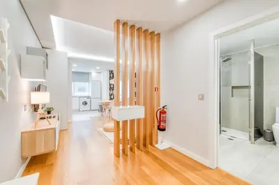 a living room with white walls and wooden floors at Casa da Praia by Amazing Madeira in Caniço
