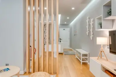 a living room with a wooden partition with a tv at Casa da Praia by Amazing Madeira in Caniço