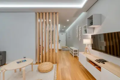 a living room with a flat screen tv and a table at Casa da Praia by Amazing Madeira in Caniço