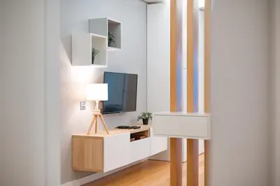 a living room with a tv and a desk with a lamp at Casa da Praia by Amazing Madeira in Caniço
