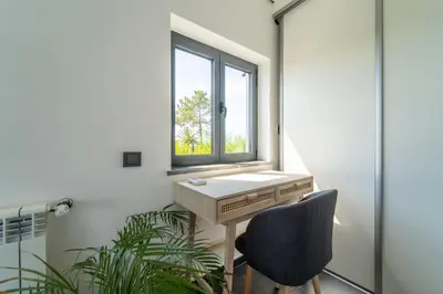a desk and a chair in a room with a window at Casa Amizade in Aljezur