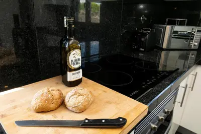 a bottle of wine and two loaves of bread on a cutting board at Casa Amizade in Aljezur