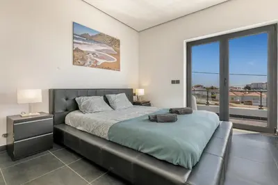 a bedroom with a bed and a large window at Casa Amizade in Aljezur