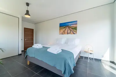 a bedroom with a large bed with a blue blanket at Casa Amizade in Aljezur