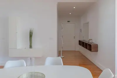 a white kitchen with a glass table and white chairs at Centre Funchal top floor terrace & large balconies in Funchal