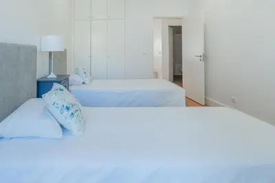 two beds in a room with white walls at Centre Funchal top floor terrace & large balconies in Funchal