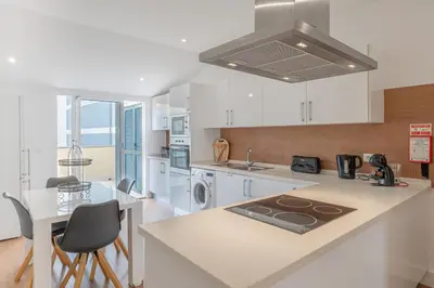 a kitchen with white cabinets and a counter top at Centre Funchal top floor terrace & large balconies in Funchal