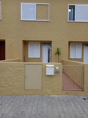 a yellow house with a gate and a fence at Charming Beach Villa Porto Santo in Porto Santo