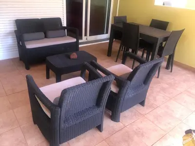 a group of chairs and tables in a patio at Charming Beach Villa Porto Santo in Porto Santo